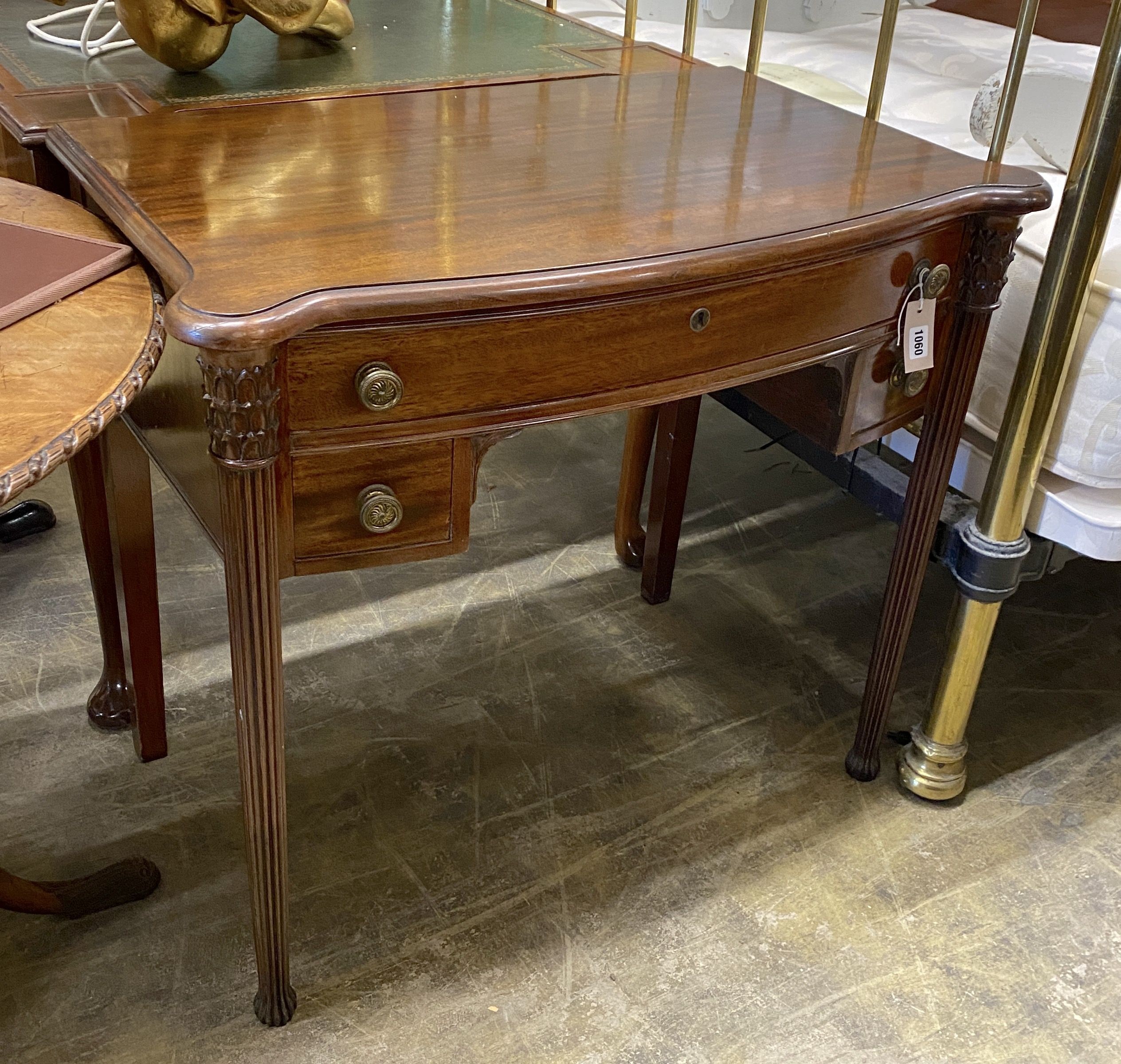 A Victorian style serpentine mahogany writing table, width 86cm, depth 51cm, height 76cm